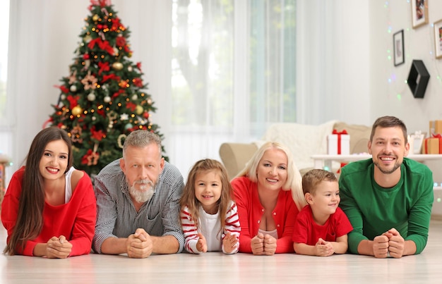 Happy family lying on floor in room decorated for Christmas