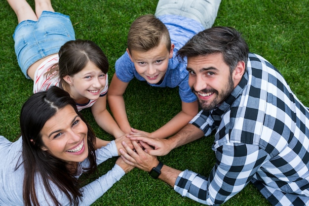 Foto famiglia felice che si trova sull'erba in parco un giorno soleggiato