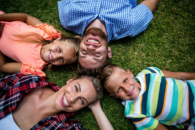 Happy family lying on grass at yard