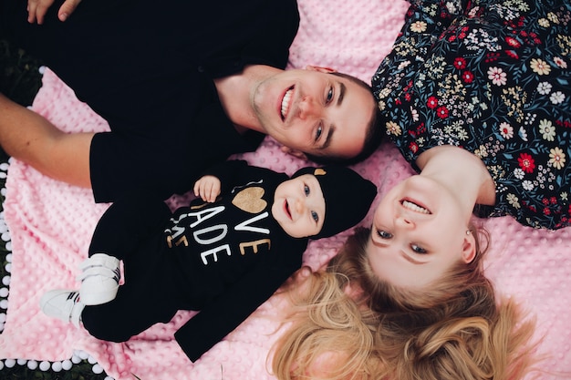 Happy family lying on pink blanket