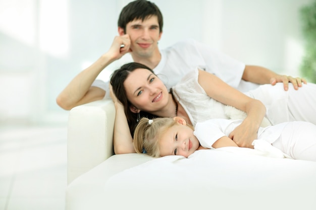 Happy family lying on the sofa on Sunday.