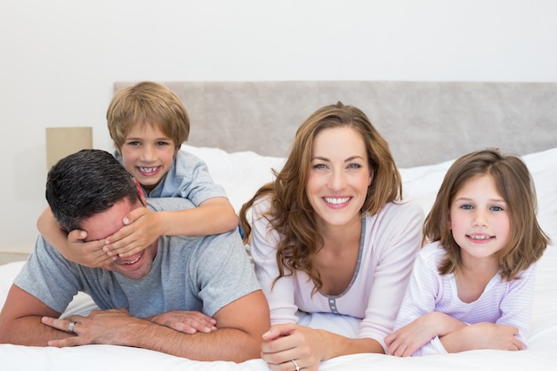 Happy family lying together in bed