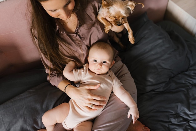 Famiglia felice mamma bambino e cane che giocano sul letto