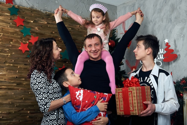 Happy family: mom, dad and three children by the fireplace for the winter holidays. Christmas eve and new year's eve.