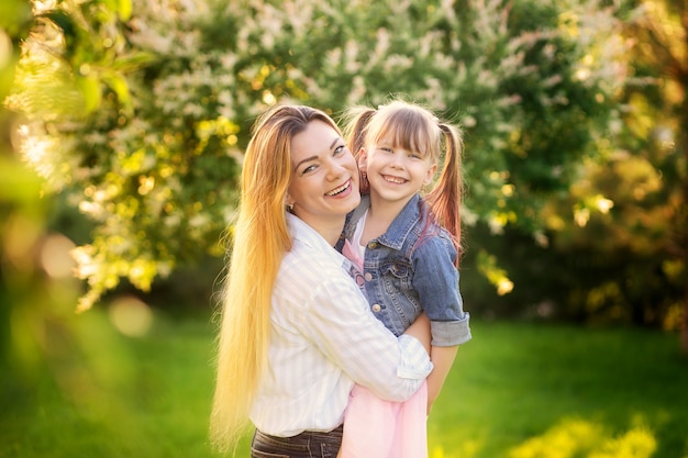 Happy family, mom and daughter in the summer park