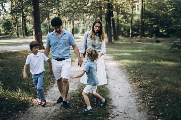 Happy family moments with kids sons in a forest