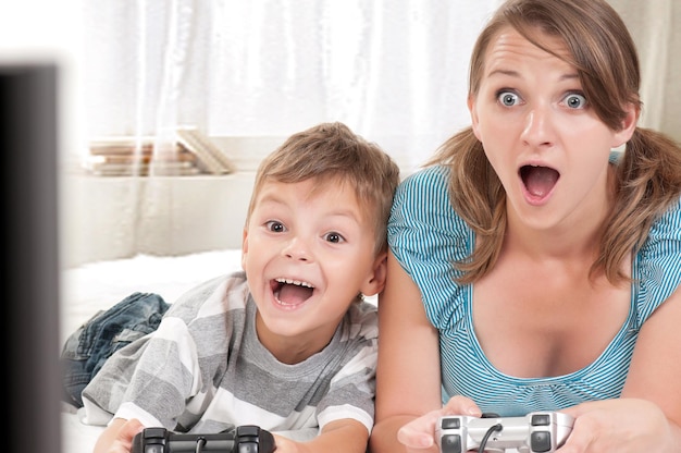 写真 ビデオゲームをしている幸せな家族の母と子供