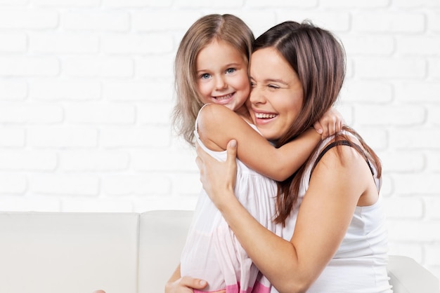 happy family. Mother and baby daughter plays, hugging, kissing at home on the sofa