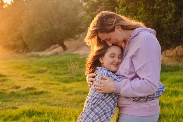 Happy family mother and child daughter in nature Park in summer on green grass