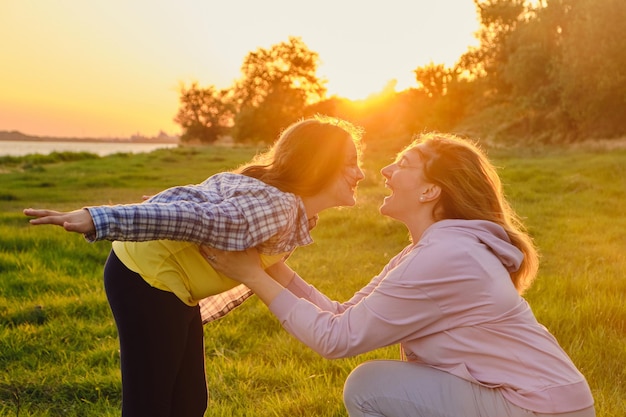 Happy family mother and child daughter in nature Park in summer on green grass