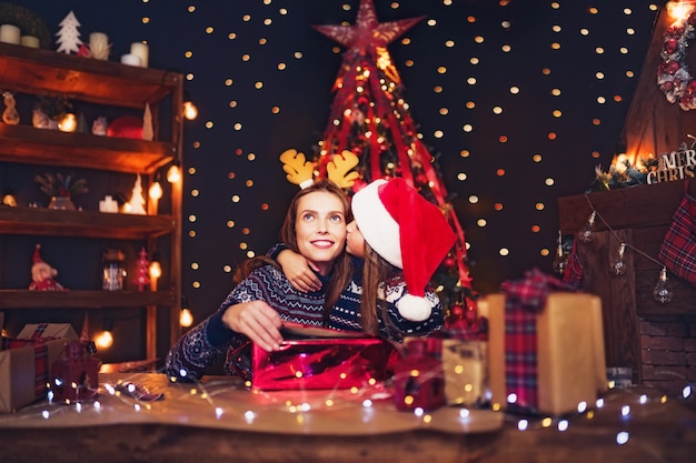 幸せな家族の母と子はクリスマスプレゼントをパックします。