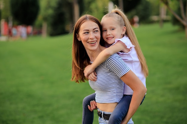 Happy family, mother and daughter in nature in the Park