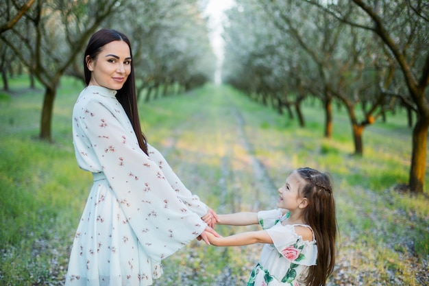 Foto una famiglia felice madre e figlia si riposano nel parco in abiti