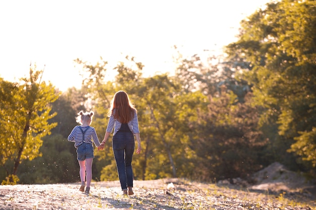 Happy family -  Mother and daughter on a walk in the sunset