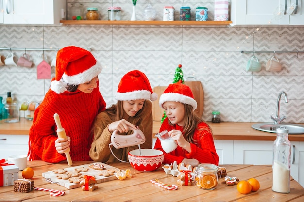 행복한 가족 엄마와 딸들이 크리스마스에 쿠키를 굽는다
