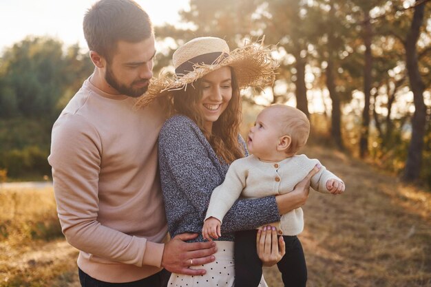 Happy family of mother family and little baby rests outdoors Beautiful sunny autumn nature