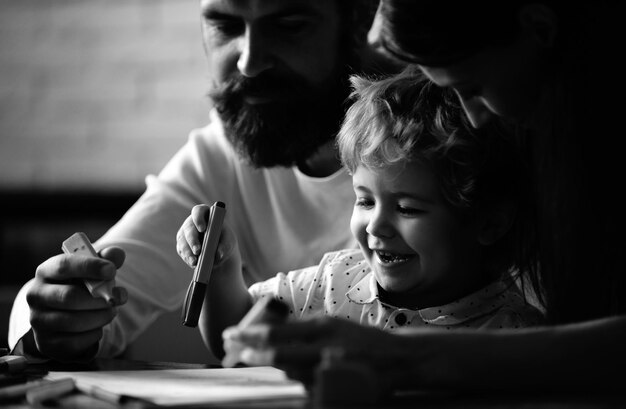 Фото Счастливая семья мать отец и ребенок сын рисуют смеются раннее детство образование дети творческие