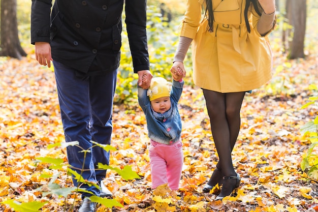 Happy family of mother, father and baby in autumn nature