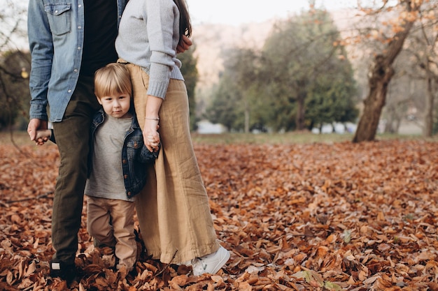 Happy family mother father and baby on autumn walk in the park