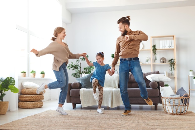 Happy family mother father and child daughter dancing at home