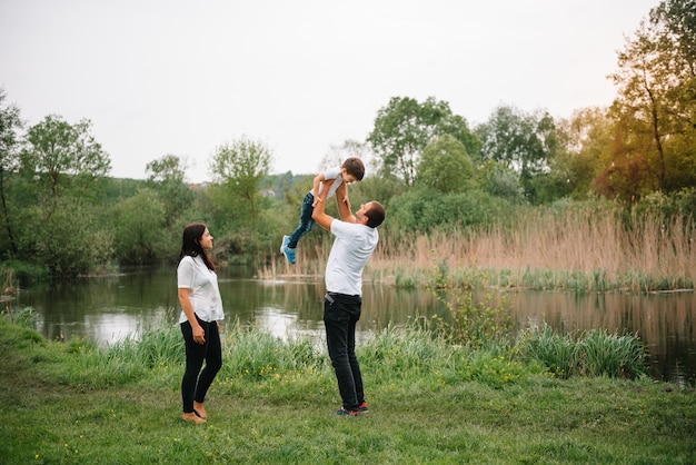 Happy family mother father and child son on nature on sunset.