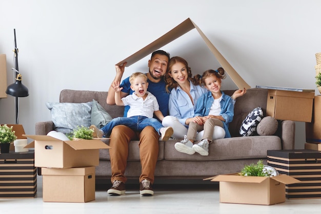 Счастливая семья, мать, отец и дети переезжают в новую квартиру и распаковывают коробки