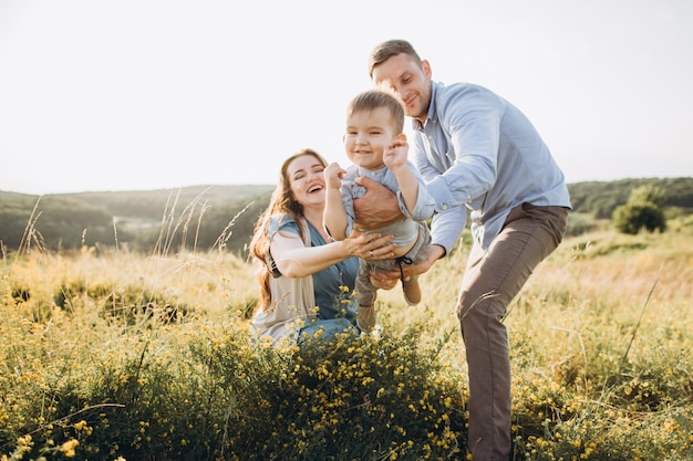 Happy family: mother, father, children son on nature at sunset