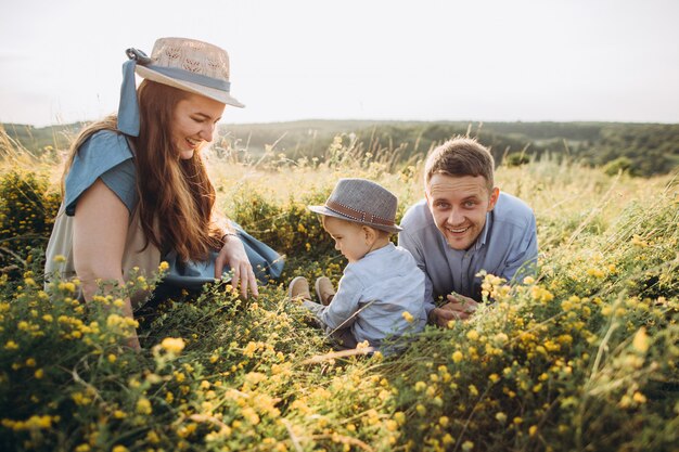 Happy family: mother, father, children son on nature at sunset