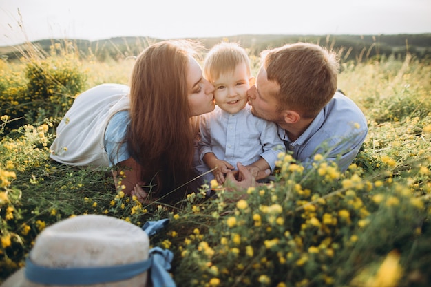 Happy family: mother, father, children son on nature at sunset