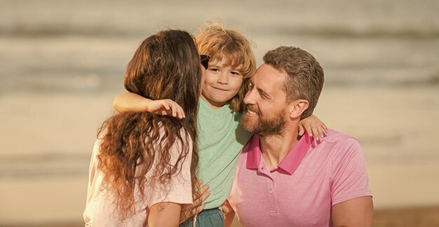 Happy family of mother father and small boy on summer beach