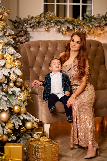 Happy family mother and little son near Christmas tree