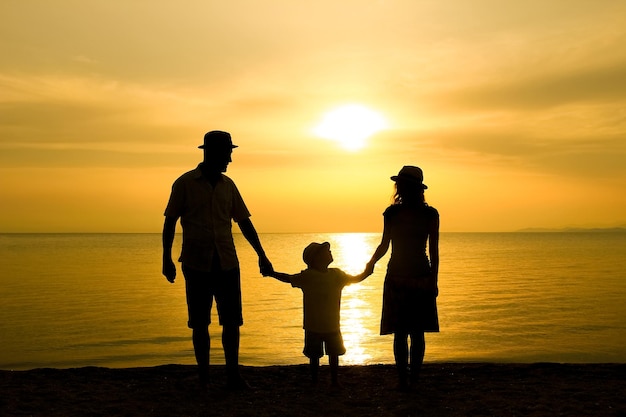 Una famiglia felice nella natura in riva al mare su una silhouette di viaggio