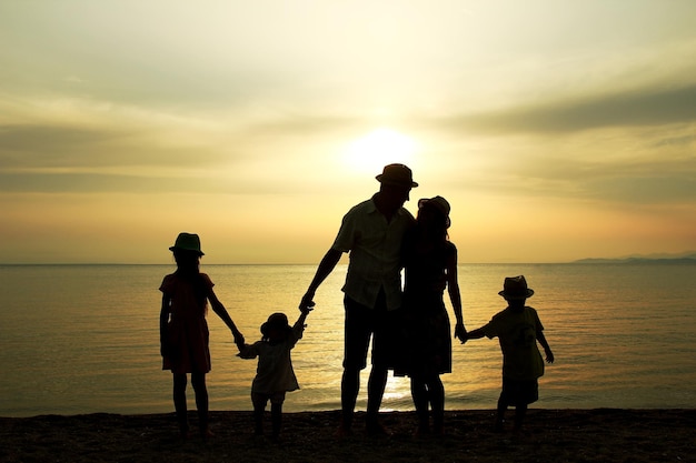 A happy family in nature by the sea on a trip silhouette