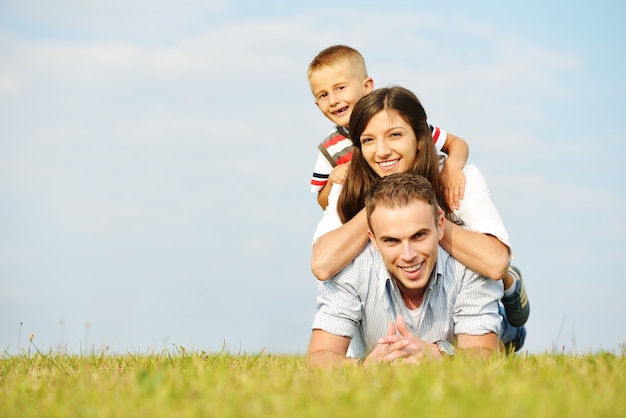 Happy family in nature having fun on grass meadow