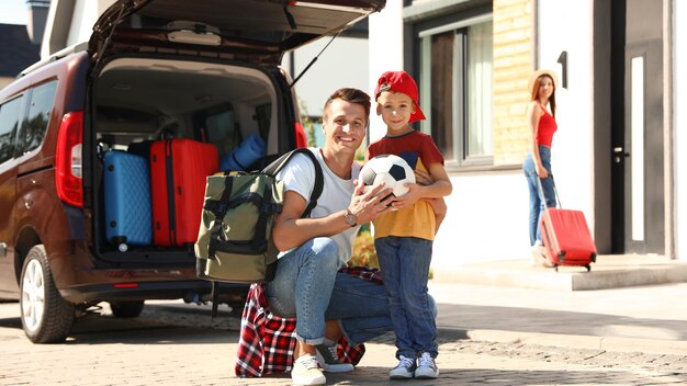 Photo happy family near car with suitcases outdoors moving day