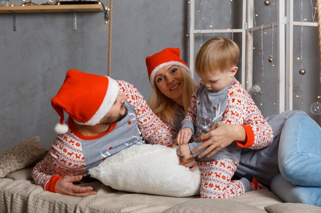 Happy family near christmas tree in bedroom.