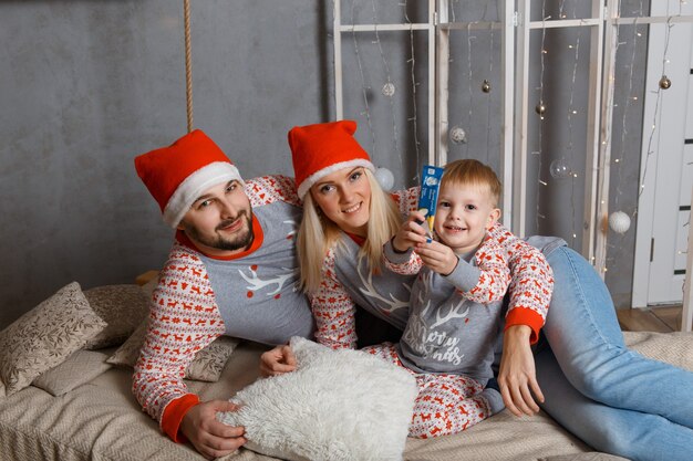 Happy family near christmas tree in bedroom.