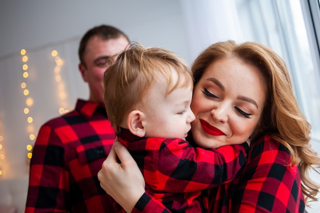 Happy family near christmas tree in cozy interior