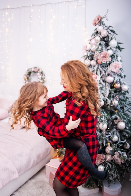 Happy family near christmas tree in cozy interior