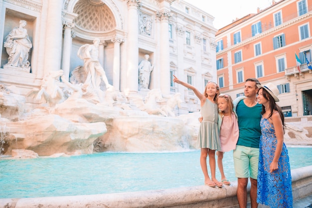 Famiglia felice vicino a fontana di trevi con la mappa della città