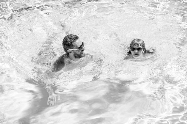 Фото Счастливая семья папы и ребенка, веселящихся в летнем бассейне на летних каникулах
