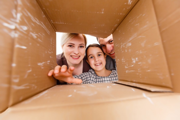 Scatola di cartone di apertura della famiglia felice - concetto in movimento