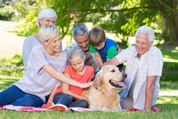 Happy family petting their dog in the park 