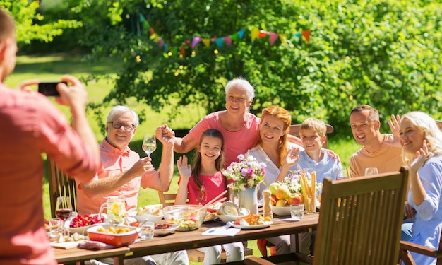 happy family photographing at dinner in garden