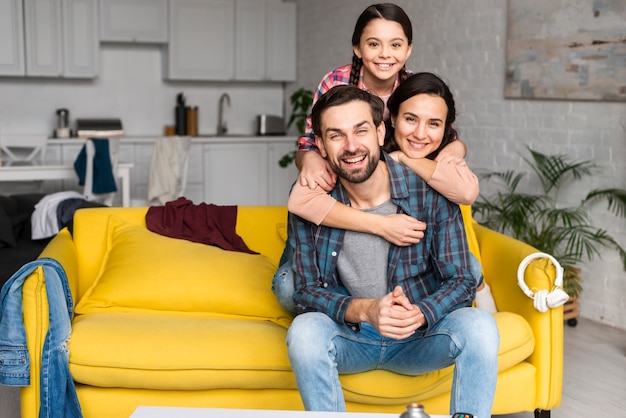 Foto famiglia felice in un mucchio e papà che si siedono sul sofà