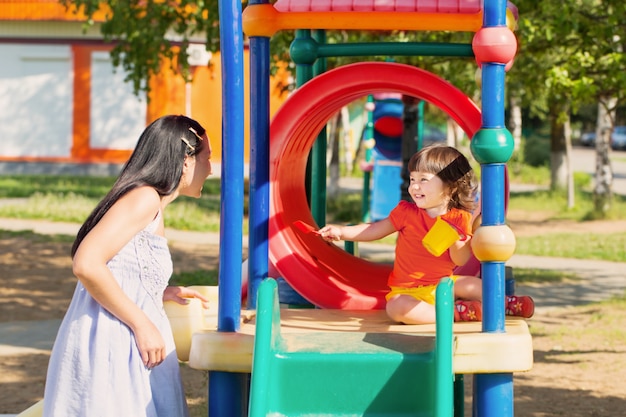 Happy family on playground in summer