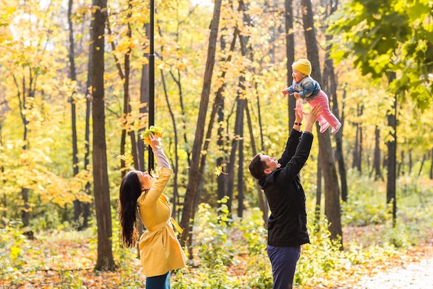 Happy family playing against blurred yellow leaves