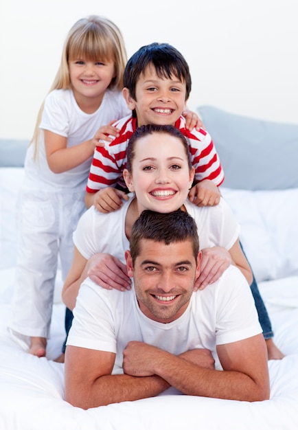 Happy family playing in bed together