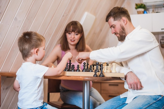 Happy family playing chess in the kitchen