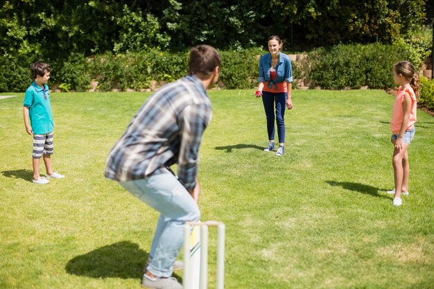 Happy family playing cricket in park